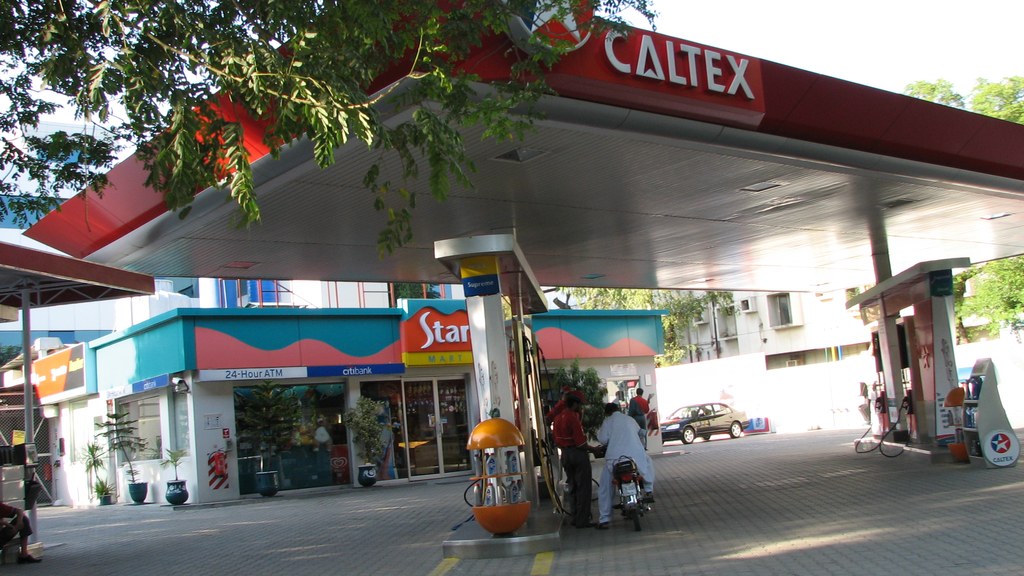 A Caltex petrol station in Islamabad with a motorcyclist refuelling at the pump under the station canopy