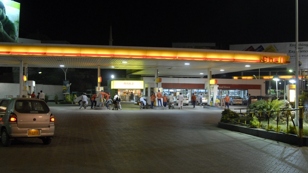 A Shell petrol station in Karachi at night with cars and motorbikes refuelling at the pumps