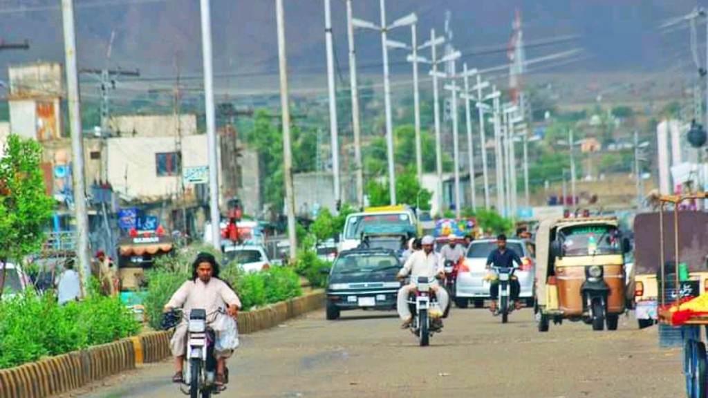 Main street of Khuzdar city in Balochistan with motorbikes, rickshaws and traffic