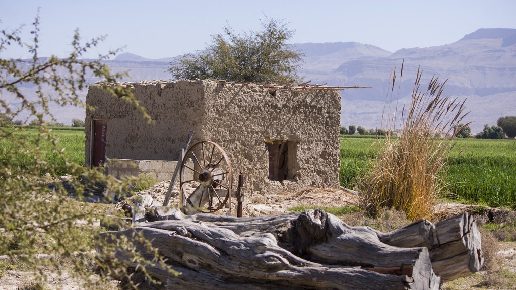 A mud house in Karakh tehsil of Khuzdar district, Balochistan, with fields and mountains behind it — several mud houses were damaged across Khuzdar district in Saturday's 5.9-magnitude earthquake