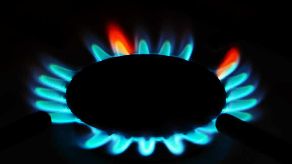 Blue flame of a domestic gas stove burner in a Karachi home kitchen.