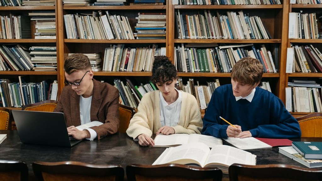 Students working on laptops in a library — file photo