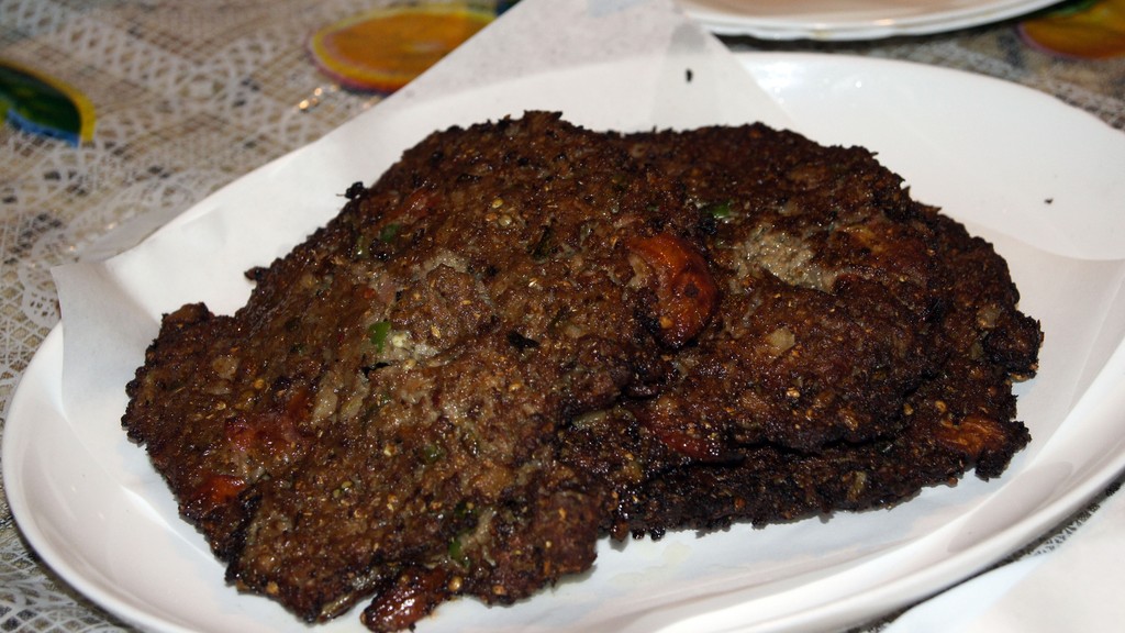 Peshawari chapli kebabs on a serving plate, flat spiced beef kebabs with tomato and crisp browned edges