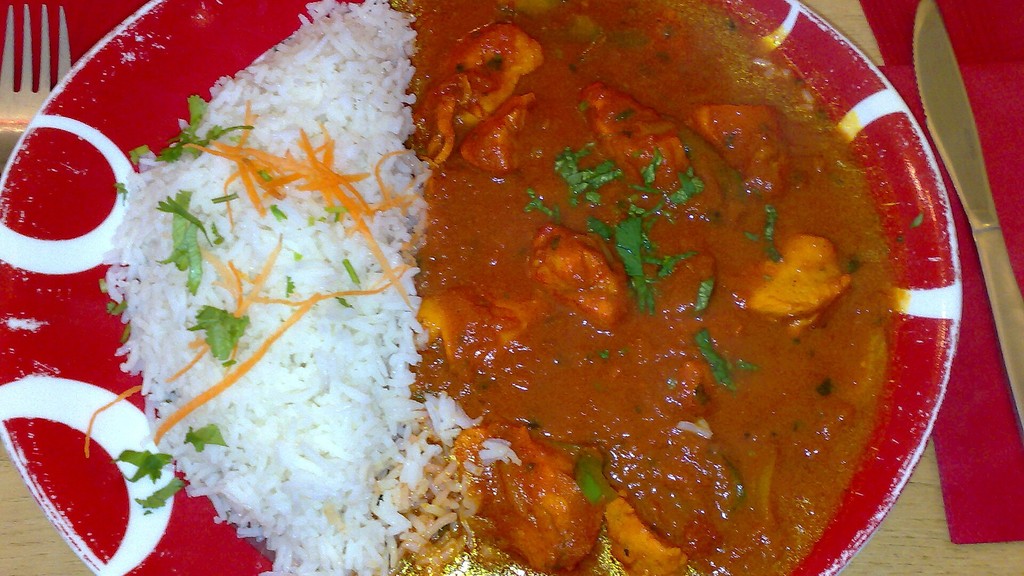 A plate of chicken jalfrezi in a rich tomato curry served with white rice, the dish prepared using this recipe
