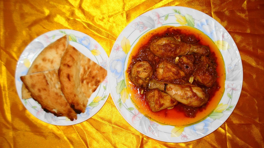 A plate of chicken qorma in a rich fried-onion and yoghurt gravy served with taftan bread, prepared using this chicken qorma recipe
