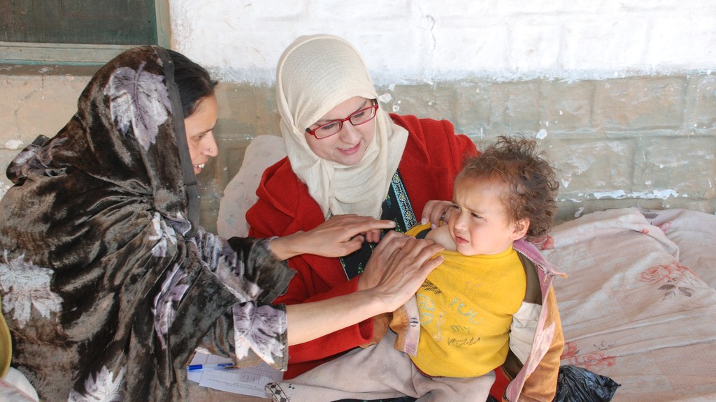 A health worker vaccinates a young child during a vaccination campaign in Pakistan, as the government discusses local vaccine production with the Asian Development Bank