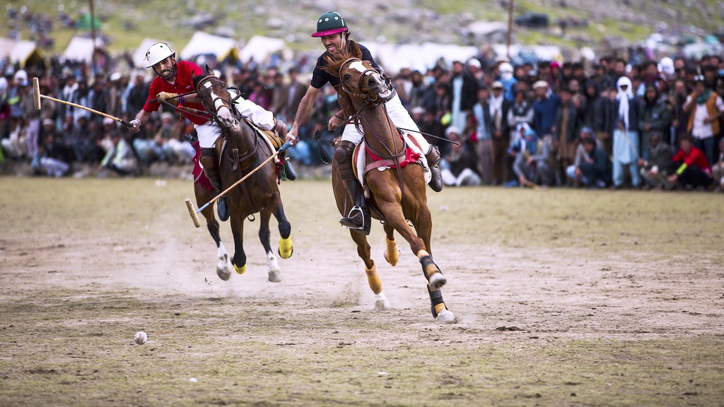 Freestyle polo players on horseback in front of a crowd at Shandur Top in Gilgit-Baltistan, the kind of mountain polo match around which Hasan Raheem filmed the 'Bewajah' music video in Gilgit