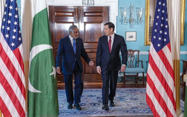 Pakistan Deputy Prime Minister and Foreign Minister Ishaq Dar, who warned the Afghan Taliban of consequences over inaction against terrorist groups, walking with US Secretary of State Marco Rubio beside the Pakistan flag at the US State Department