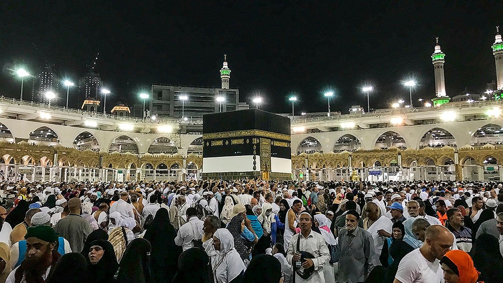 Pilgrims gathered around the Kaaba at night inside Masjid al-Haram in Makkah