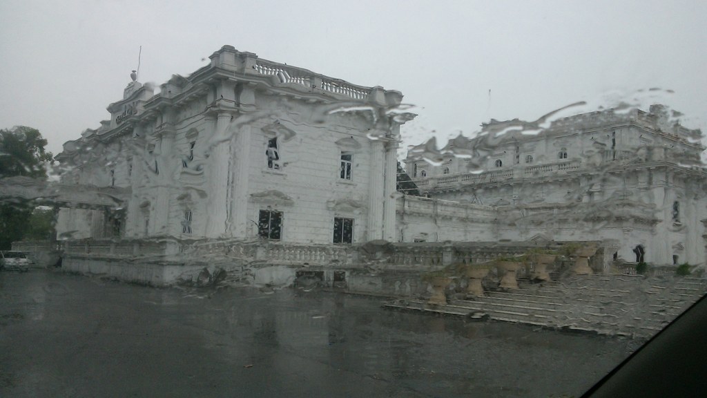 The Quaid-e-Azam Library (Montgomery Hall) in Lahore seen in rain, with wet streets after showers