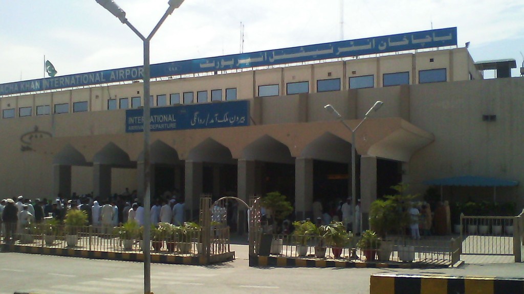 Travellers gathered outside the terminal of Bacha Khan International Airport in Peshawar, from where Umrah pilgrims can now depart without vaccination until October 25
