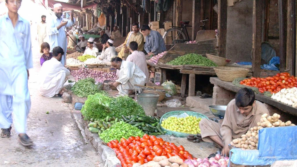 Vegetable stalls at a market in Peshawar with piles of tomatoes, onions, potatoes and greens, the everyday items tracked by Pakistan's weekly SPI inflation data