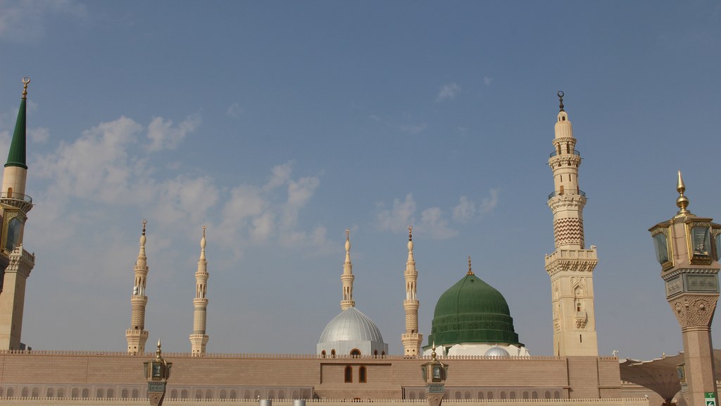The Prophet's Mosque in Medina with its Green Dome and minarets under a blue sky