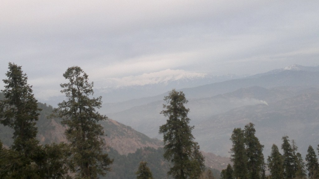 Snow-capped peaks above pine-covered hills near Murree.