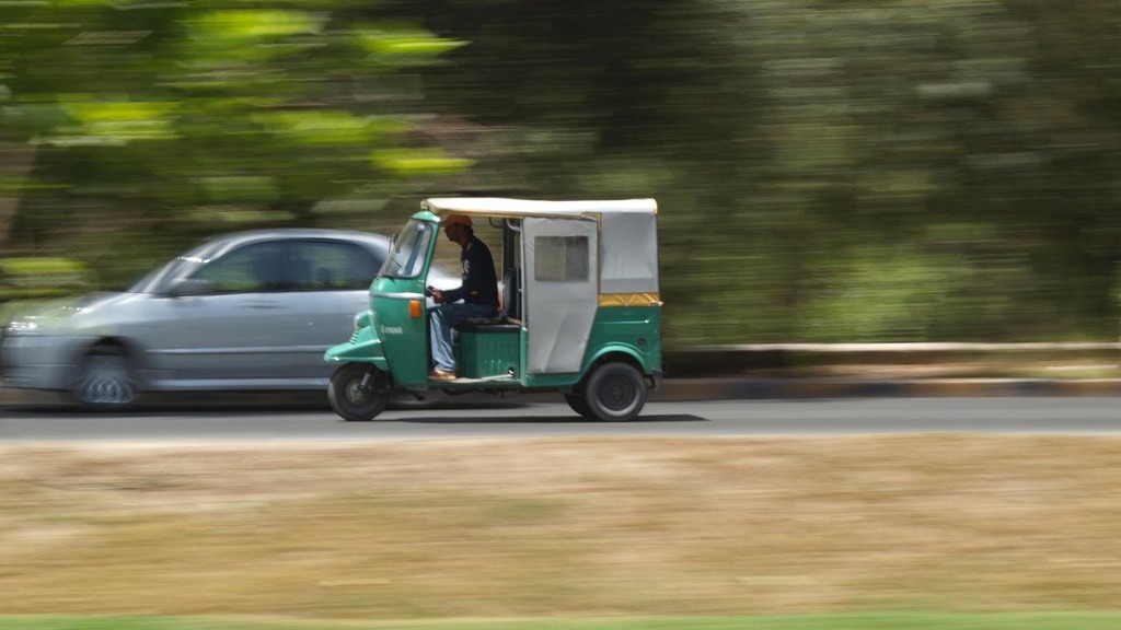 An auto-rickshaw on a road beside the canal in Lahore, Pakistan, one of the transport modes tracked by the Mobility Index.