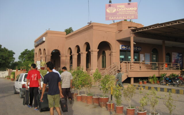 Passengers with luggage outside a Daewoo intercity bus terminal in Pakistan