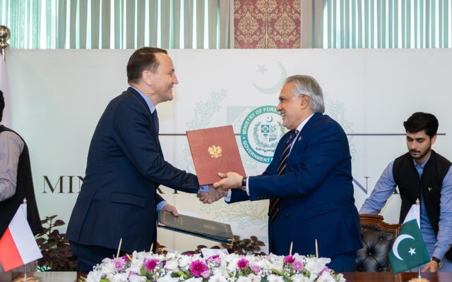 Pakistan's Foreign Minister Ishaq Dar exchanging documents at an official meeting