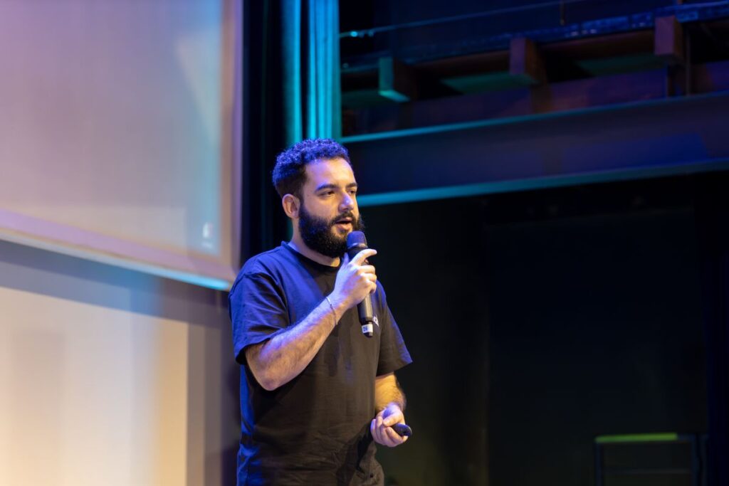 A speaker addressing the audience on stage during a technology conference