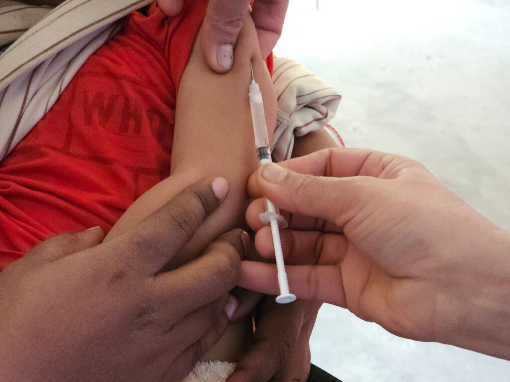 A young child receiving a vaccination from a healthcare professional