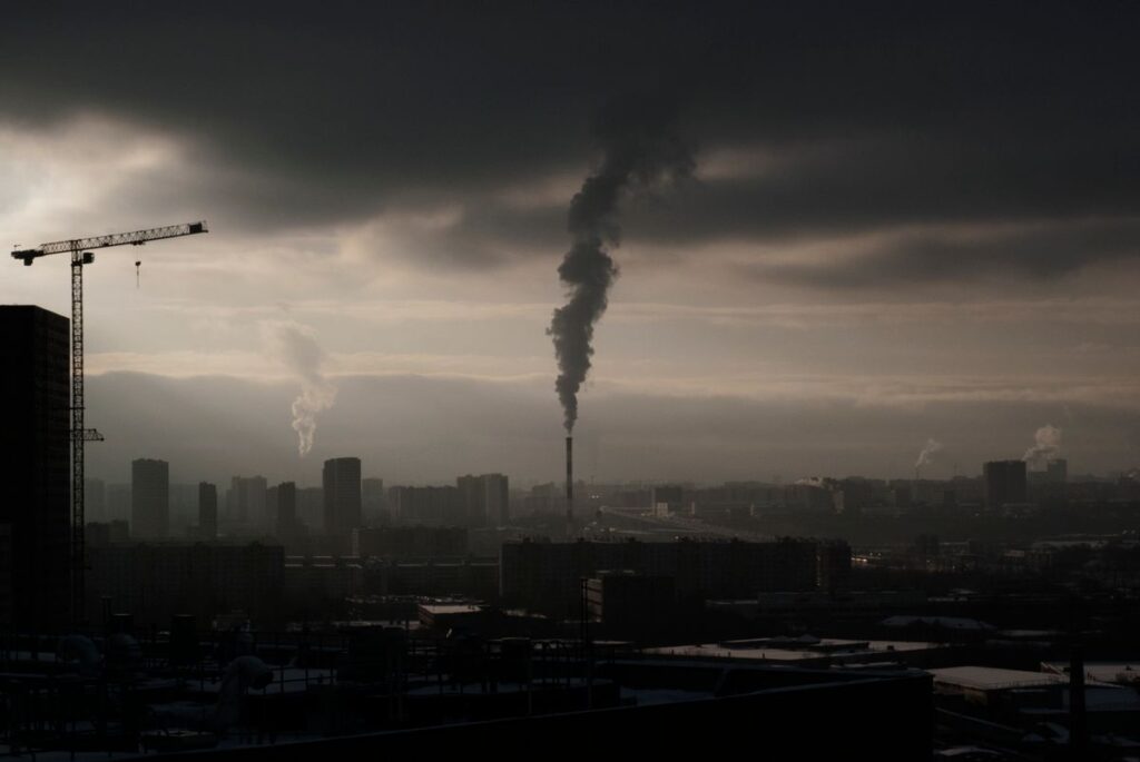 An aerial view of a city skyline enveloped in thick industrial smog and haze