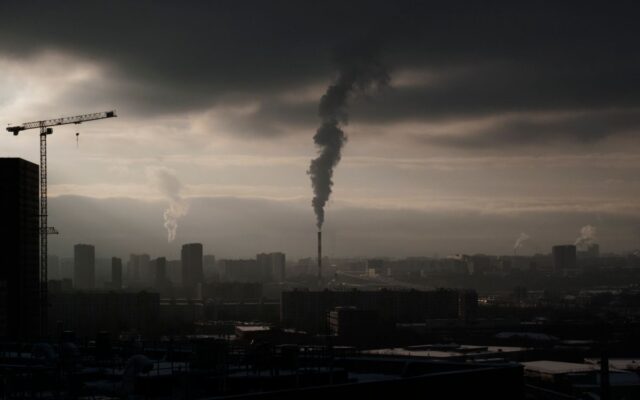 An aerial view of a city skyline enveloped in thick industrial smog and haze